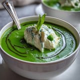 Green spring pea soup with dollops of airy ricotta and a drizzle of mint oil.