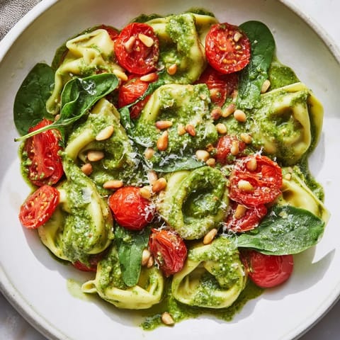 Summer feast with bright pesto tortellini salad, bursting with fresh, colorful ingredients.