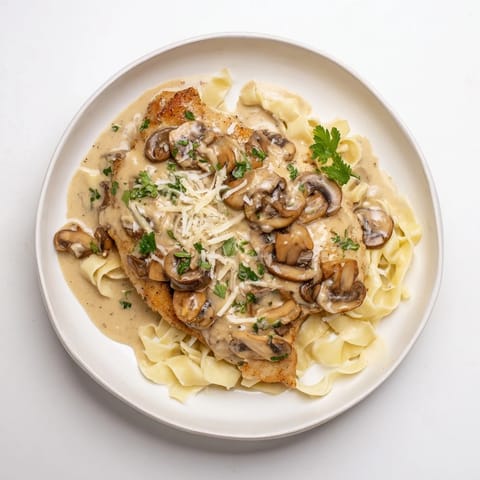 Tender chicken breasts simmered in rich Marsala wine sauce with sautéed cremini mushrooms, topped with Parmesan and parsley.