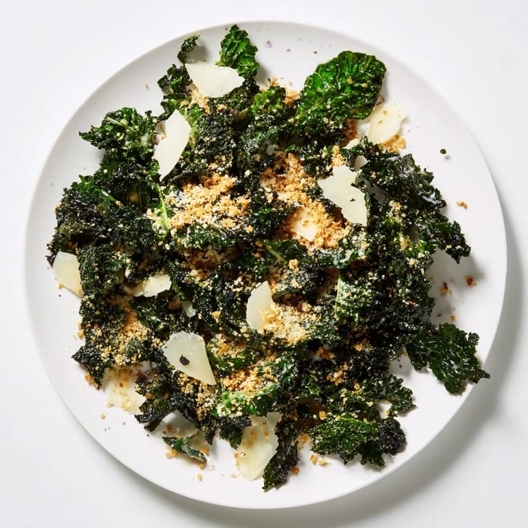 A bright, vegetarian Garlic Parmesan Kale Salad features glossy kale, shaved Parmesan, and crunchy breadcrumbs, perfect as a side or light lunch.
