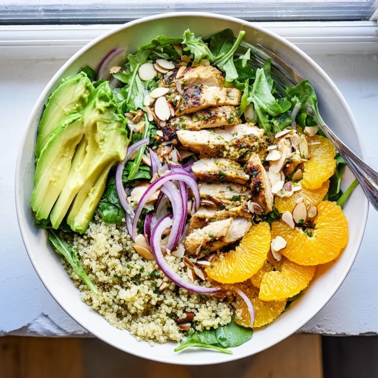 A healthy Citrus Herb Chicken Salad Bowl ready to eat, drizzled with citrus vinaigrette and garnished with fresh herbs.